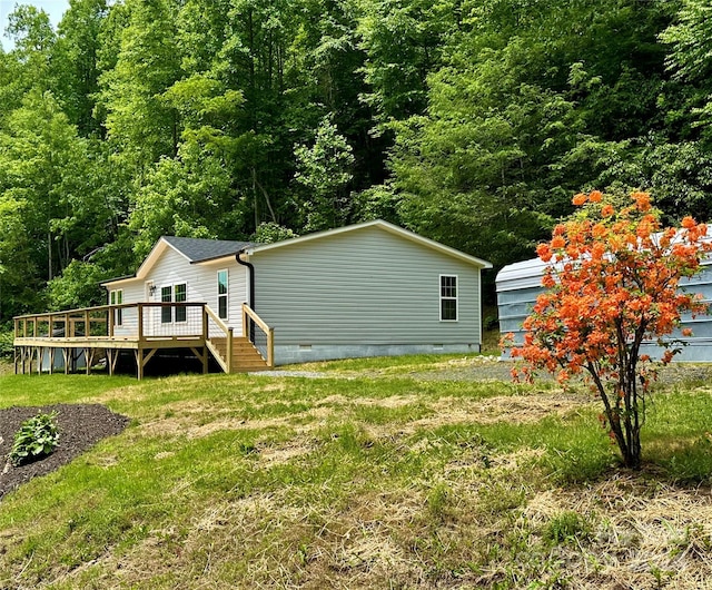 rear view of house with a deck and a yard