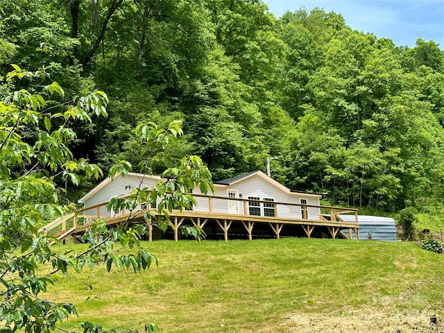 rear view of house with a yard and a deck