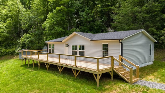 rear view of house featuring a lawn and a deck