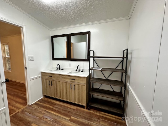 bathroom featuring crown molding, vanity, a textured ceiling, and hardwood / wood-style flooring