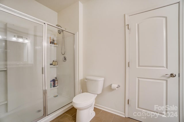 bathroom with an enclosed shower, tile floors, and toilet