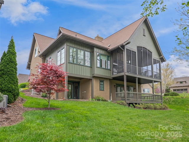 back of property featuring a lawn and a sunroom