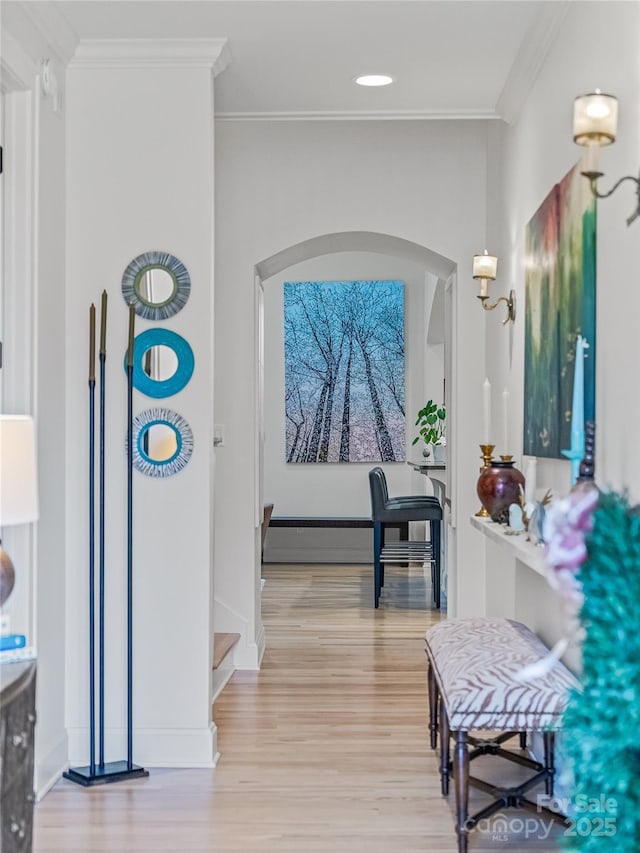 hallway featuring ornamental molding and light hardwood / wood-style floors