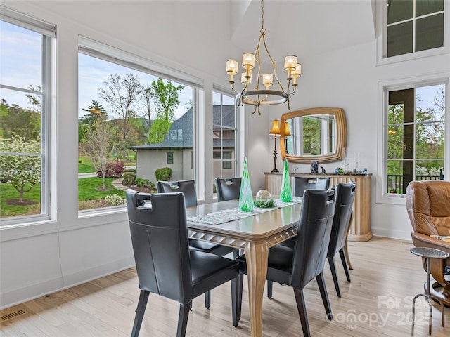 dining room featuring light wood-type flooring and a notable chandelier