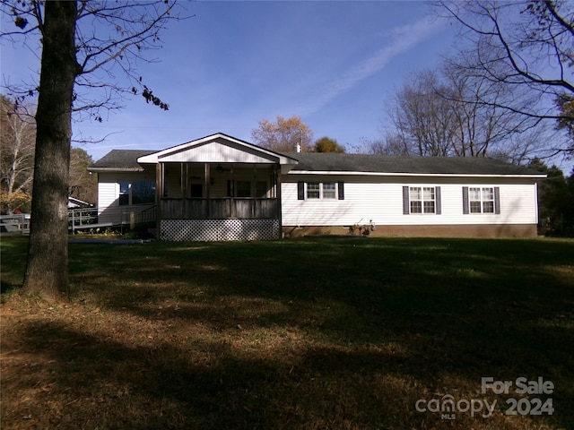 rear view of house featuring a lawn