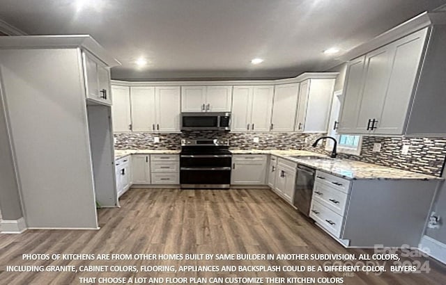 kitchen featuring sink, stainless steel appliances, backsplash, wood-type flooring, and white cabinets