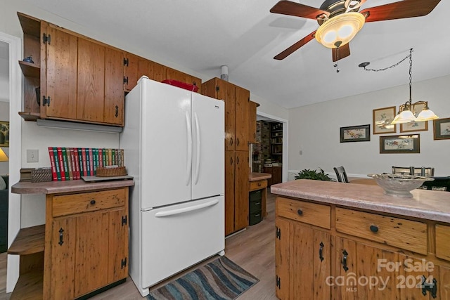 kitchen with light hardwood / wood-style floors, hanging light fixtures, white refrigerator, and ceiling fan