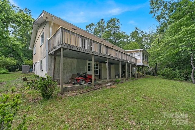 back of house with a deck and a lawn