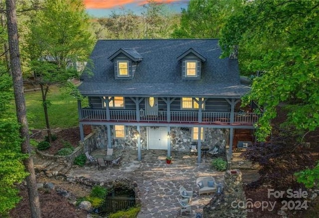 back house at dusk with a patio