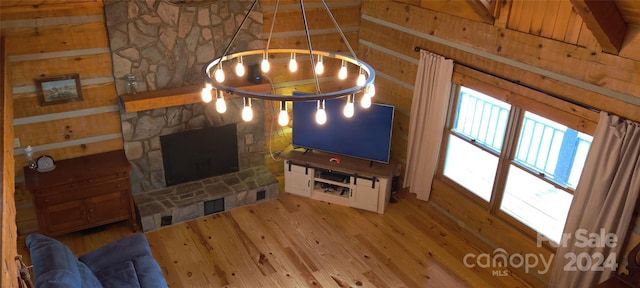 living room featuring a stone fireplace and hardwood / wood-style flooring