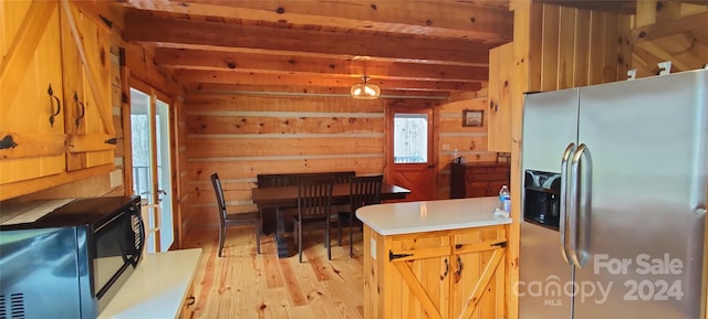 kitchen featuring wooden walls, light hardwood / wood-style floors, stainless steel refrigerator with ice dispenser, and beamed ceiling