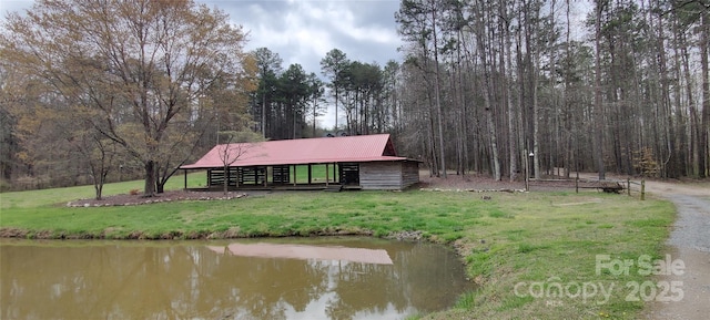 rear view of house featuring a water view and a yard