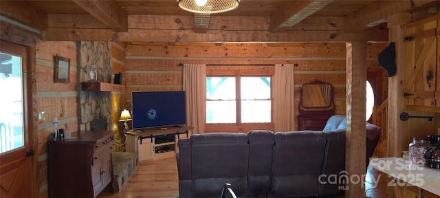 living room with beamed ceiling, wood ceiling, wooden walls, and light wood-type flooring