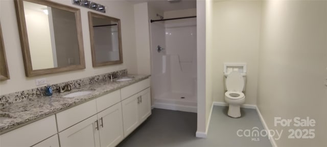 bathroom featuring vanity, toilet, and a shower