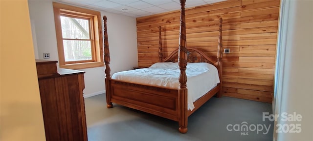 bedroom featuring a drop ceiling and wood walls