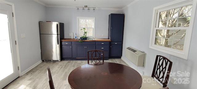 dining room with crown molding and light hardwood / wood-style floors