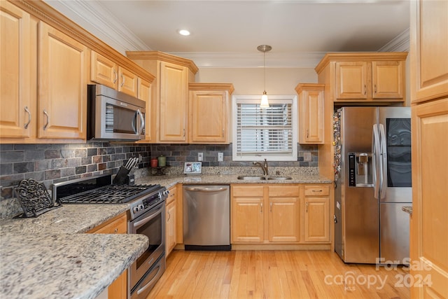 kitchen with appliances with stainless steel finishes, light hardwood / wood-style flooring, tasteful backsplash, and sink