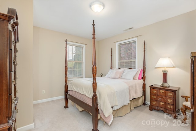 bedroom with visible vents, baseboards, and light colored carpet