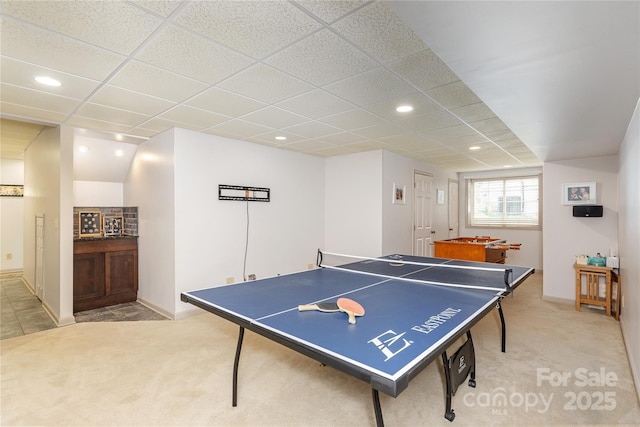 recreation room with recessed lighting, a drop ceiling, and light carpet