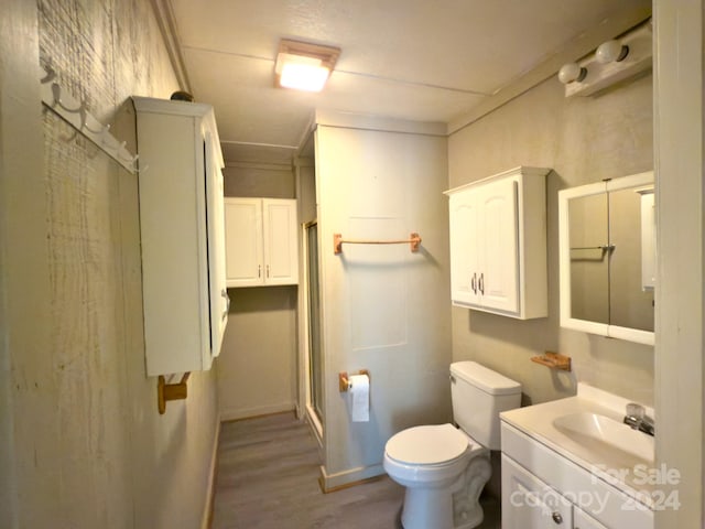 bathroom with vanity, hardwood / wood-style flooring, toilet, and a shower with door