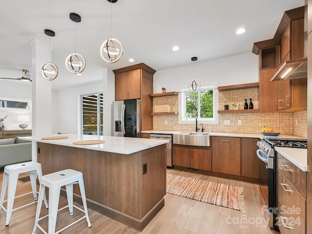 kitchen featuring backsplash, pendant lighting, stainless steel appliances, and sink