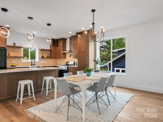 dining room with light hardwood / wood-style flooring, sink, and a notable chandelier