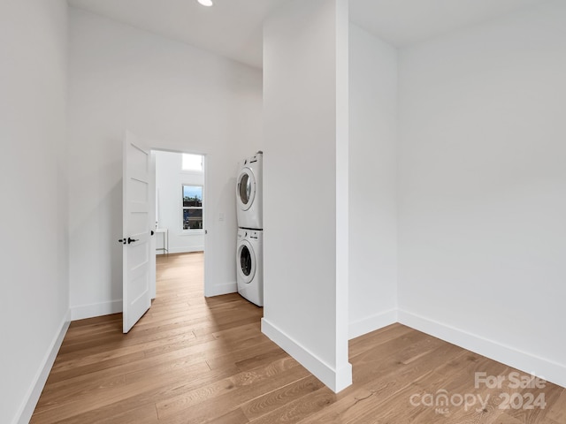 laundry area featuring light hardwood / wood-style floors and stacked washer / dryer