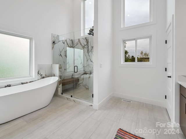 bathroom featuring separate shower and tub, vanity, and tile flooring