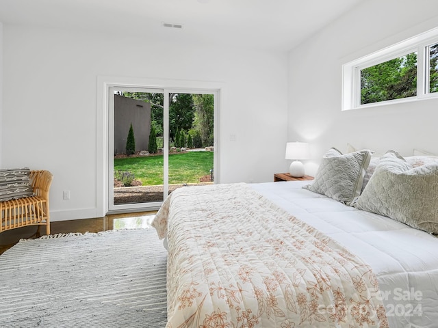 bedroom with hardwood / wood-style floors and access to outside