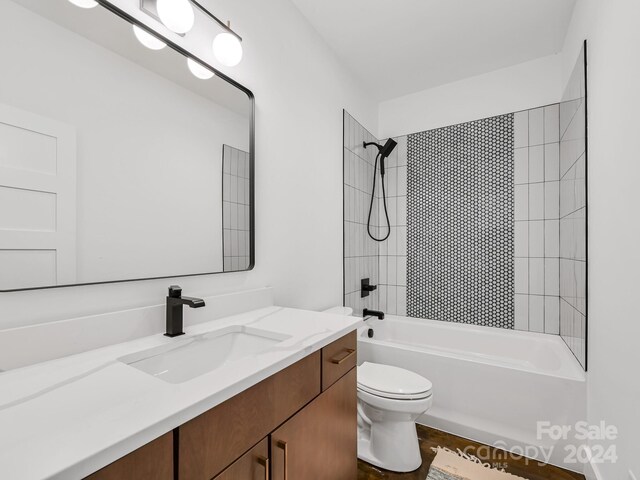 full bathroom featuring oversized vanity, toilet, and tiled shower / bath