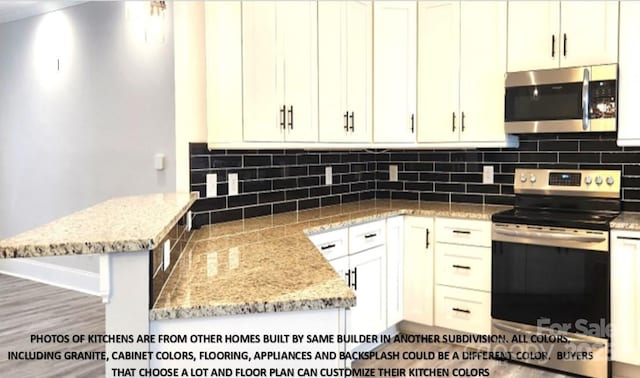 kitchen with hardwood / wood-style flooring, light stone countertops, tasteful backsplash, white cabinetry, and stainless steel appliances