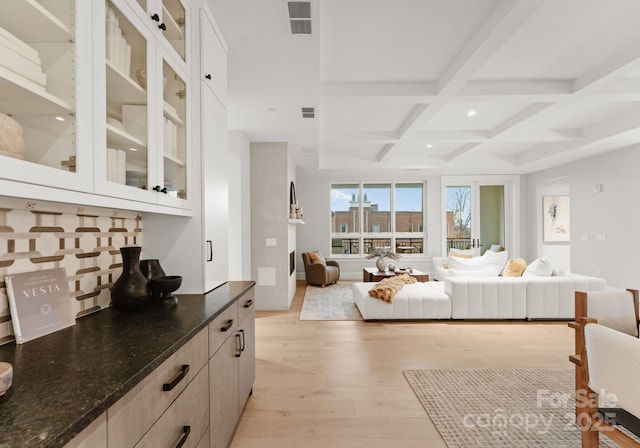 bedroom featuring coffered ceiling, light hardwood / wood-style floors, and beamed ceiling