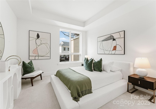 carpeted bedroom featuring a tray ceiling