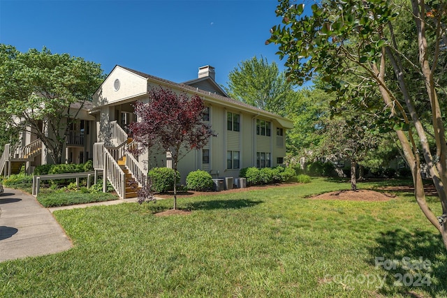 view of side of home featuring a lawn and cooling unit