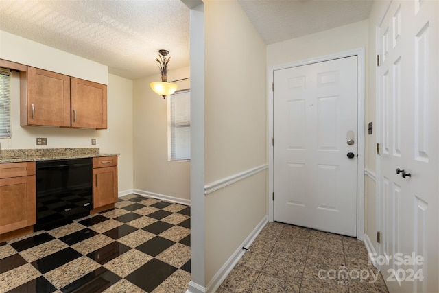 kitchen featuring dishwasher and a textured ceiling