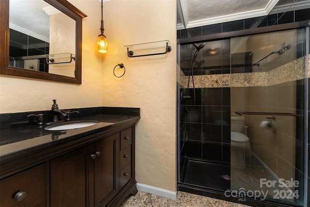 bathroom with vanity, a shower with door, toilet, ornamental molding, and a textured ceiling