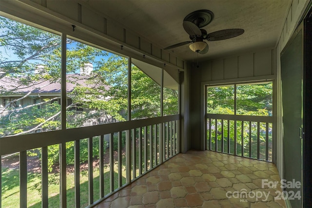 unfurnished sunroom featuring ceiling fan