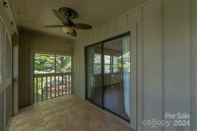 unfurnished sunroom featuring ceiling fan