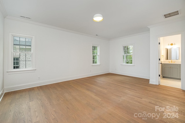 empty room featuring crown molding and light wood-type flooring