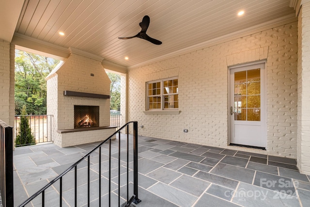 view of patio with an outdoor brick fireplace and ceiling fan