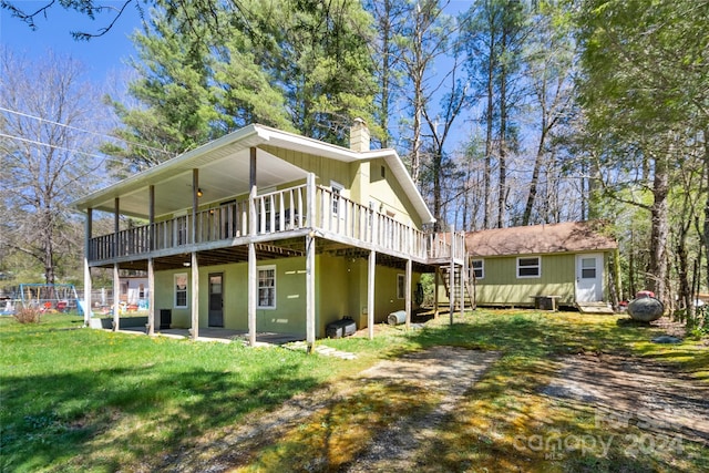 back of house featuring a wooden deck and a yard