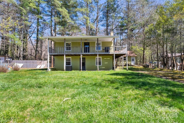 rear view of house featuring a deck and a lawn