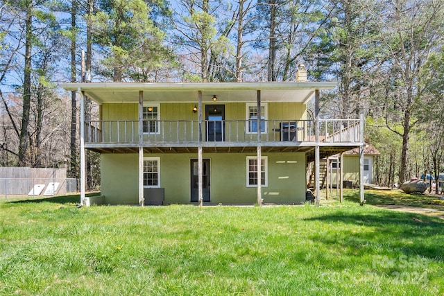 back of house featuring a deck and a lawn