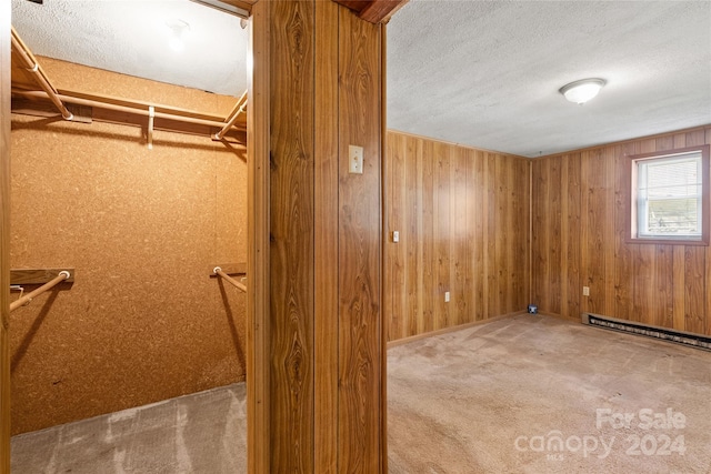 walk in closet with a baseboard heating unit and carpet