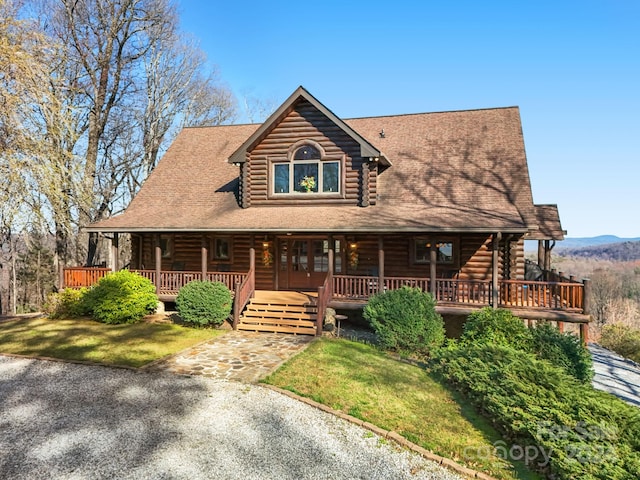 log cabin featuring a front yard and covered porch