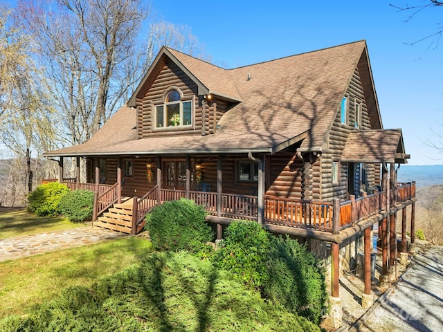 log-style house featuring a front lawn and a porch