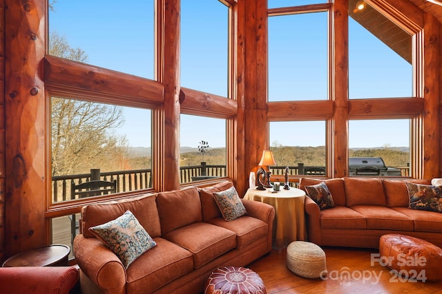 living room with light hardwood / wood-style floors and a towering ceiling