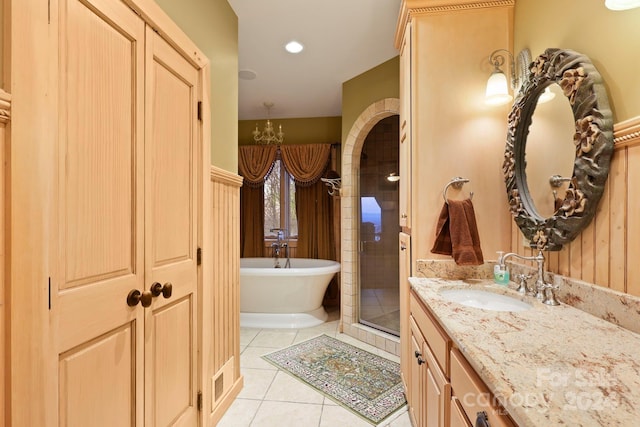 bathroom with shower with separate bathtub, vanity, a chandelier, and tile floors