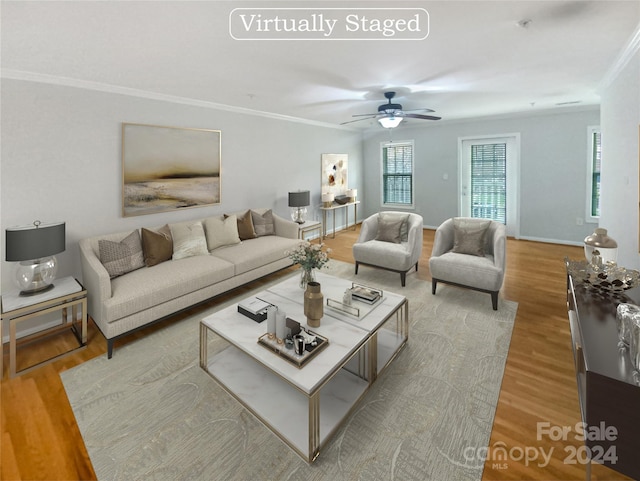 living room featuring light hardwood / wood-style floors, ceiling fan, and crown molding