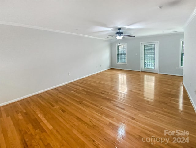 empty room with crown molding, ceiling fan, and light wood-type flooring